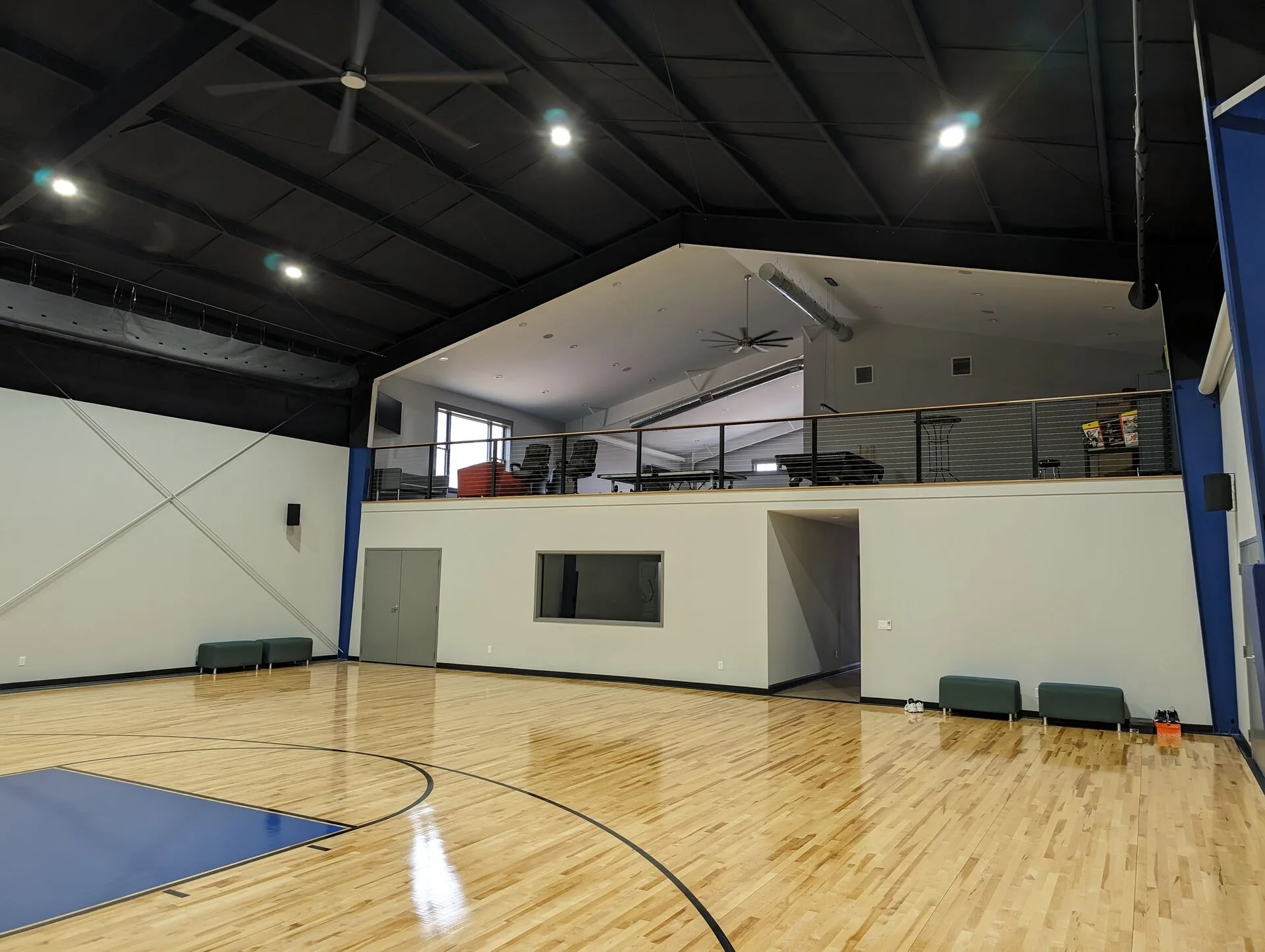 Private indoor basketball court with maple hardwood floor and loft above by Harber Built