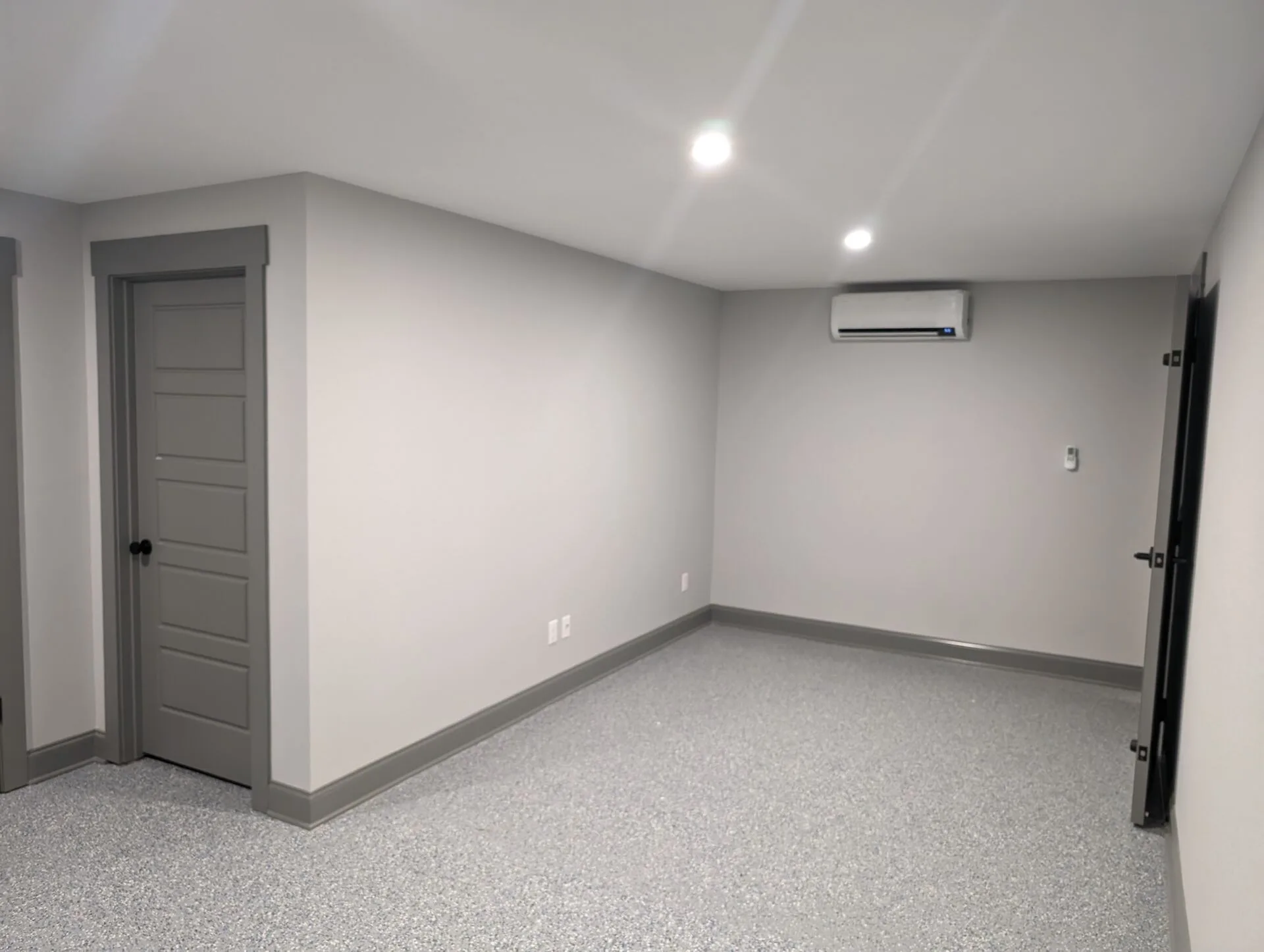 Finished basement room with epoxy-flake flooring, mini-split HVAC, and recessed lighting